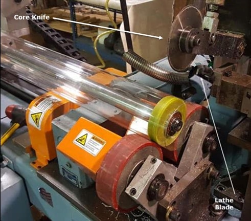 A section of transparent tubing being cut in a machine