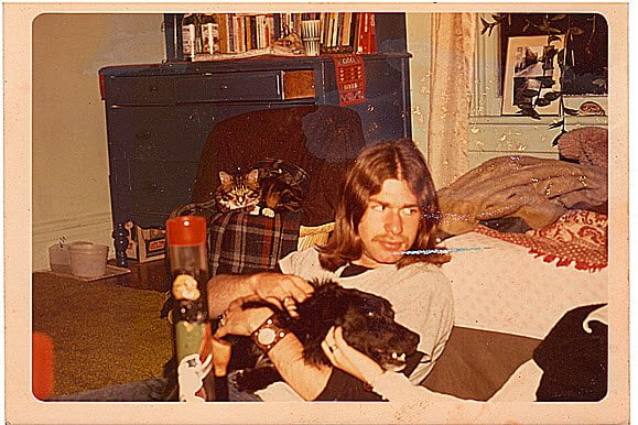 Charles Busada petting a dog in 1975. The Jerry Garcia tribute project is in the foreground