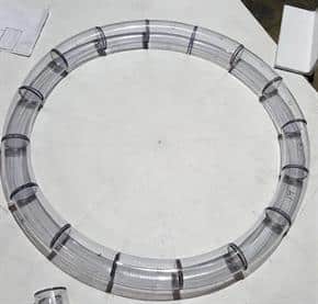 A circle of tubing made by mitering many short bends together