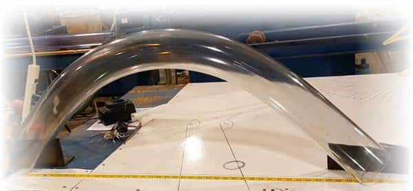 A large clear tubing bend in a tight radius over a bend schematic on the table