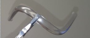 A small three dimensional bend held by pliers