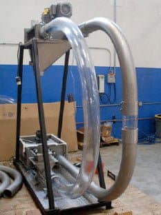 a clear U bend tube at use in a test machine for puck conveyance.
