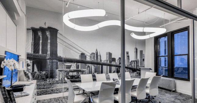 A modern office space with LED light tubing suspended from the ceiling