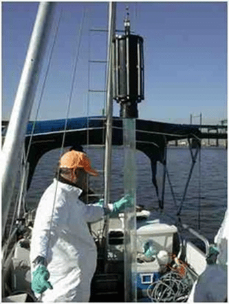 Man on a boat checking a core sample tube to be placed in the ocean