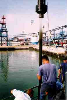 Removing a full marine core sample tube from the ocean at a dock