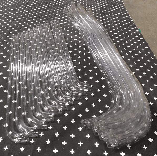 A lineup of many clear tubing bends in a row.